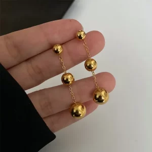 ¡Uy! Aretes tres bolitas largo